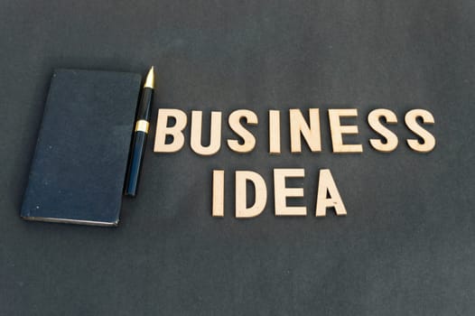 business idea background concept. Wooden cubes words Business ideas isolated on black background. Design for ideal poster, web, cover, ad, social media, promotion.