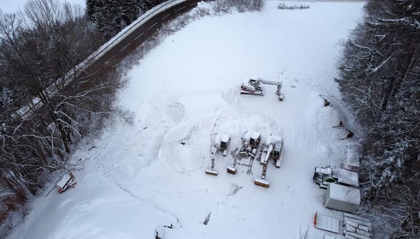 Aerial view with a drone of a road and excavator in winter