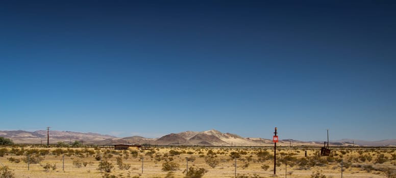 View of the desert in Nevada. Lots of sand, mountains and little vegetation.