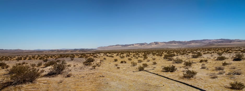 View of the desert in Nevada. Lots of sand, mountains and little vegetation.