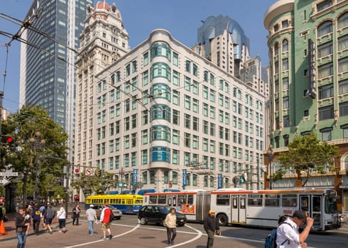 San Francisco, USA - July 25, 2008:   people downtown in San Francisco are shopping on a summer day. The overhead bus and streetcar passing the main road.