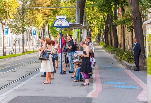 Vienna, Austria - July 23, 2009: people wait at the Busstop Waehringerstrasse  in the downtown center of Vienna, Austria.