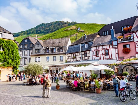 Bernkastel Kues, Germany - September 19, 2009: people enjoy the summer day at market place with medival half timbered houses in Bernkastel-Kues, Germany.