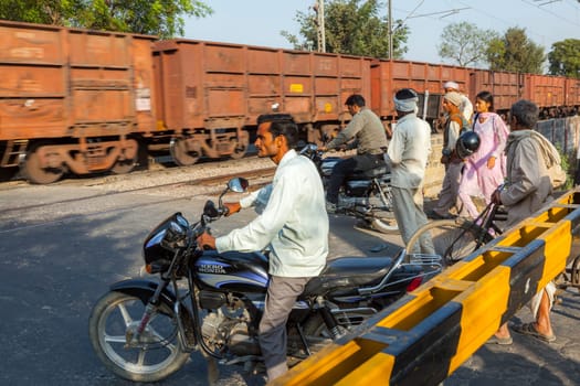 Fatehpur Sikri, India -  November 16, 2011:  people wait at the railway crossing near Fatehpur Sikri, India to cross the street.