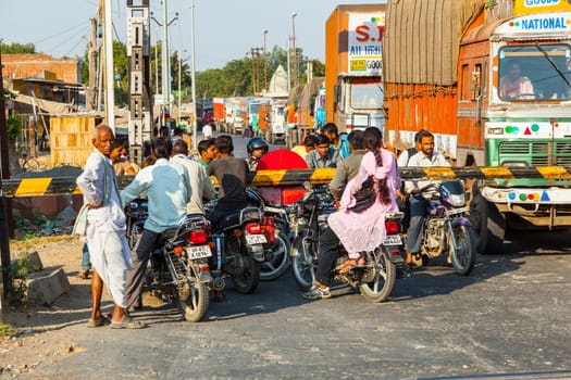 Fatehpur Sikri, India - November 16, 2011: people wait at the railway crossing near Fatehpur Sikri, India to cross the street.