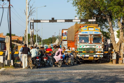 Fatehpur Sikri, India -  November 16, 2011: people wait at the railway crossing near Fatehpur Sikri, India to cross the street.
