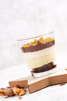 Dessert with chocolate cream, cake and nuts in a glass, sweet food, christmas season