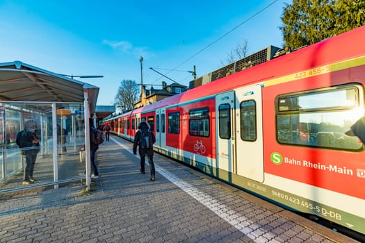 Eschborn, Germany - February 27, 2018:  people waiting outside at the trai platform of  the S-Bahn, the public transportation system in Frankfurt for the metro.
