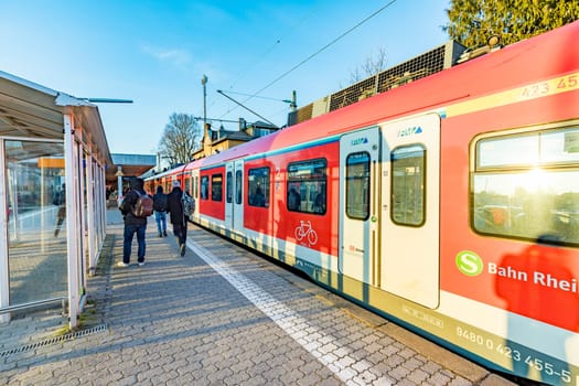 Eschborn, Germany - February 27, 2018:  people waiting outside at the trai platform of  the S-Bahn, the public transportation system in Frankfurt for the metro.
