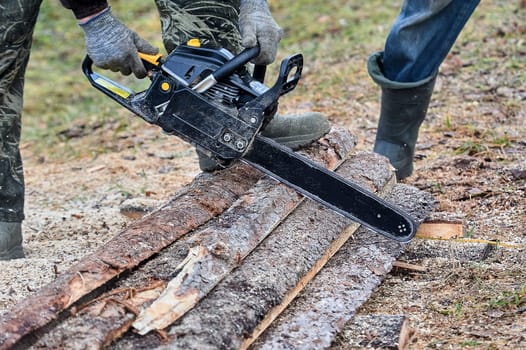 a chainsaw is used to cut wood outdoors. High quality photo