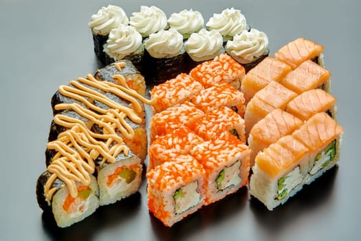 A set of delicious and juicy sushi on a black stand. High quality photo