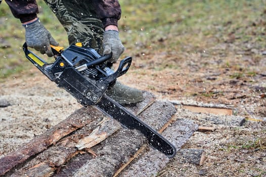 a chainsaw is used to cut wood outdoors. High quality photo