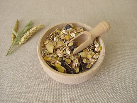 Fruit muesli with whole grain flakes and dried fruits in a wooden bowl