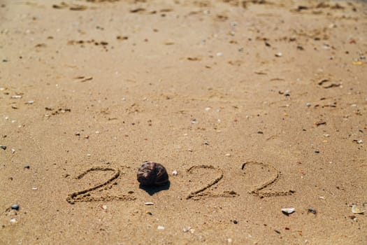 Word 2022 Written on the Sand of a Beach. With Copy Past Space
