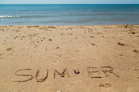Text Summer Written on the Sand of a Beach. Sea on a Background of Letters