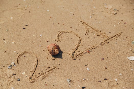 Word 2021 Written on the Sand of a Beach. New Year 2021 text on the sea beach. Vacation relax