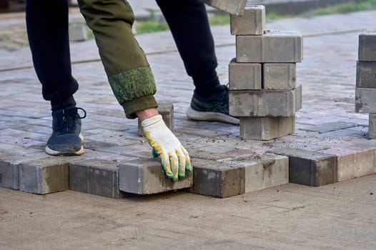laying paving slabs on the sand with your hands. High quality photo