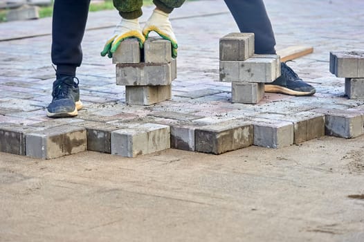 laying paving slabs on the sand with your hands. High quality photo