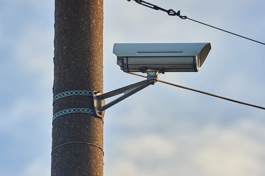 A security camera is hanging on a concrete post. High quality photo