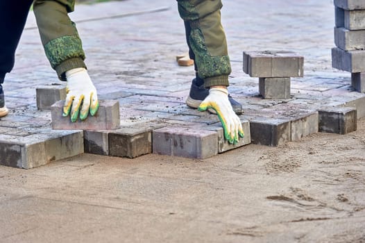 laying paving slabs on the sand with your hands. High quality photo