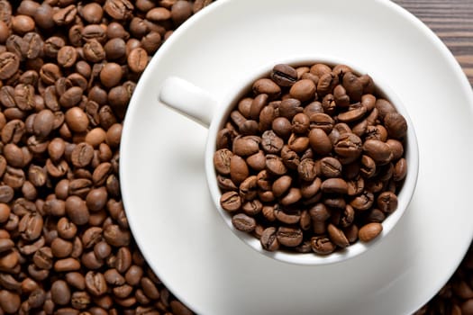 White coffee mug filled with coffee beans. High quality photo