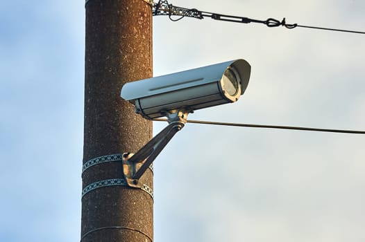 A security camera is hanging on a concrete post. High quality photo