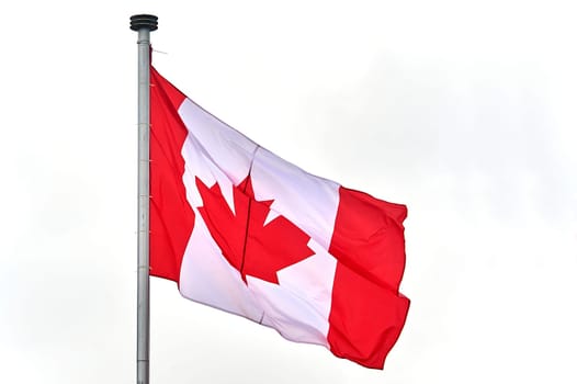 The flag of Canada hangs on the flagpole. High quality photo