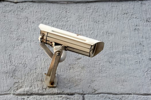 A security camera is hanging on a concrete post. High quality photo