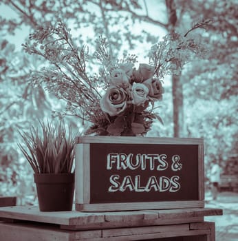 Outdoor menu blackboard with decorated flower in vintage effect