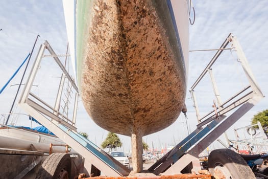 Yacht on trailor dry dock out of sea water for hull cleaning from barnicles etc
