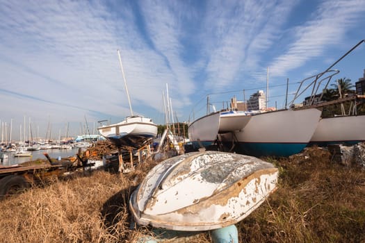 Yachts boats abandoned harbor scrap yard.