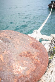 rusty bollard with line. Particular of a rusty bollard