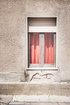 Red curtain behind the window on gray wall
