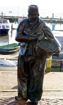 Volendam,Netherlands – December 31,2014: The sculpture The Fisherman by the artist Jan van Baarsen on the promenade of the city of Volendam on December 31,2014 in Volendam.