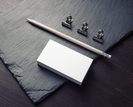 Photo of blank business cards, pencil and clips. Mockup for ID.