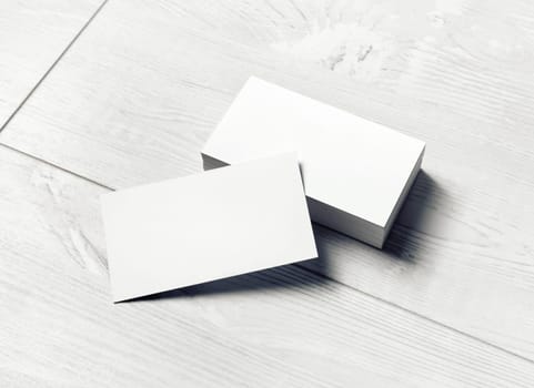 Blank business cards on light wooden background. Mockup for branding identity. Template for graphic designers portfolios.