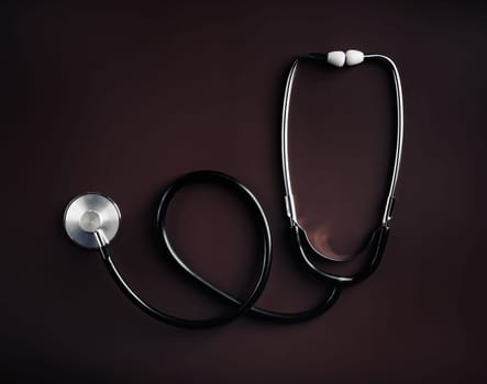 Medical stethoscope on dark background. Top view. Flat lay.