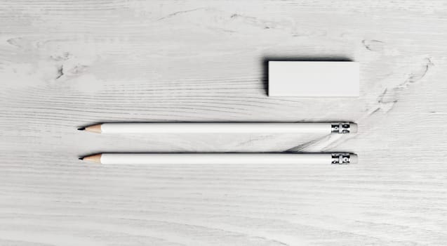 Simple blank pencils and eraser on light wooden background. Top view. Flat lay.