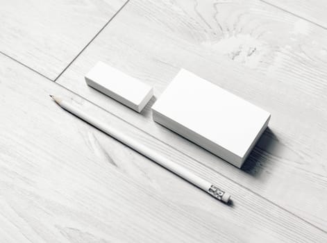 Blank stationery set. Blank business cards, pencil and eraser on light wooden background.