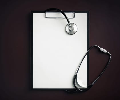 Clipboard with white paper and medical stethoscope. Copy space. Top view. Flat lay.