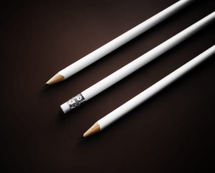 Photo of three simple blank pencils on dark background.