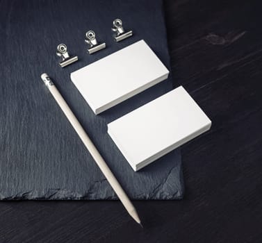 Blank corporate stationery set. Photo of blank business cards, pencil and clips.