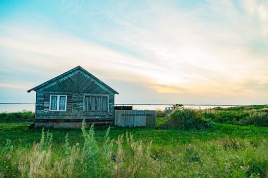 Old Wooden House by the Sea. Wonderful Landscape with a Beautiful Sunset.