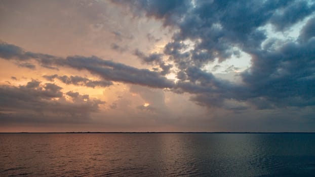 Beautiful Landscape of the Sunset on the Beach. Calm Weather with Blue Clouds in the Blue Sky Reflected in the Water.