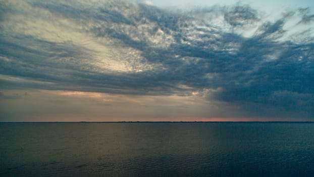 Beautiful Landscape of the Sunset on the Beach. Calm Weather with Blue Clouds in the Blue Sky Reflected in the Water.