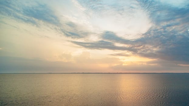 Beautiful Landscape of the Sunset on the Beach. Calm Weather with Blue Clouds in the Blue Sky Reflected in the Water.