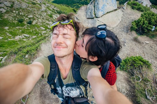 Aerial view of the Great Green Ridge. Guy and Girl Standing on a Big Hill against the Backdrop of a Huge Mountain Landscape.