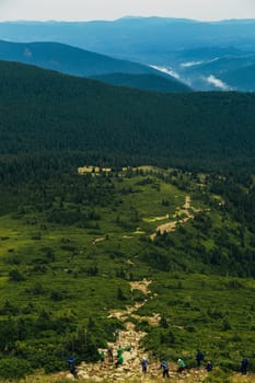 Mountain Hiking Through a Large Green Meadow.
