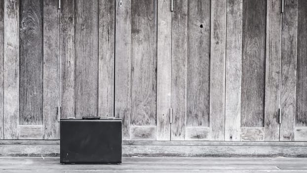 Black business leather briefcase, handbag with key lock at office, company wooden background