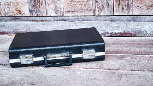 Black business leather briefcase, handbag with key lock at office , company wooden background